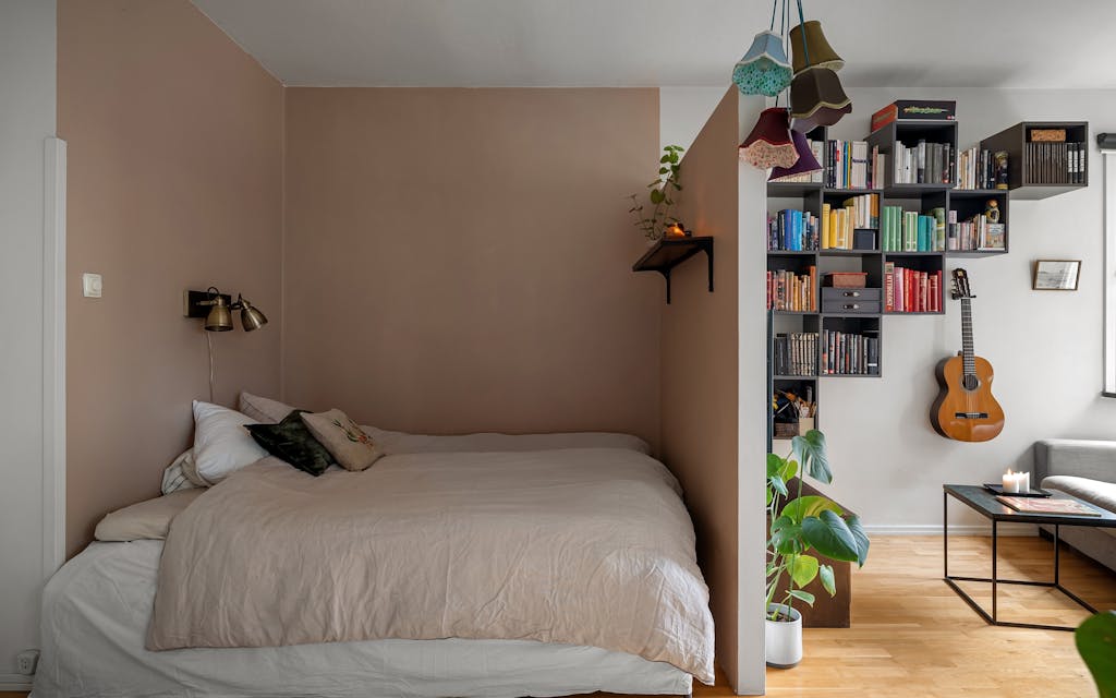 Chambre d'ado avec bibliothèque garnie de livres et une guitare