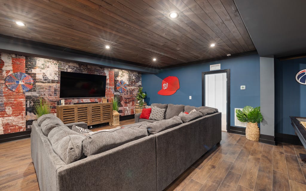 Cave aménagée en salle de séjour avec canapé et télévision