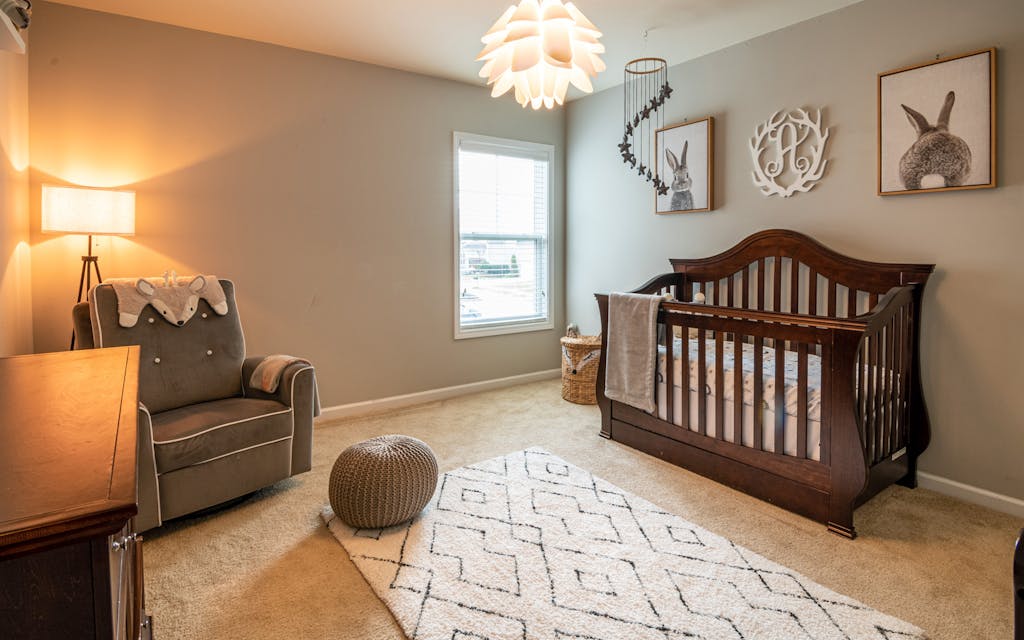Chambre de bébé décorée avec lit à barreaux et fauteuil
