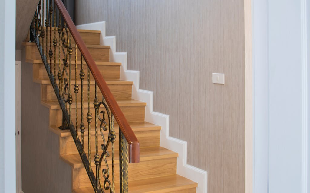 Escalier en bois à rénover avec rampe en fer forgé