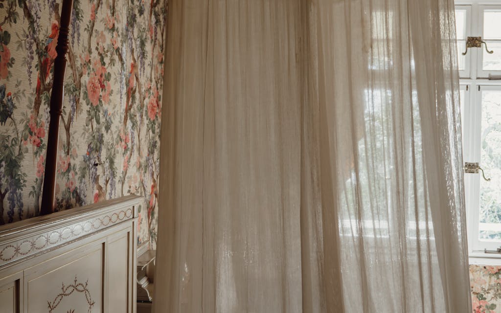 Chambre romantique avec papier peint floral derrière le lit