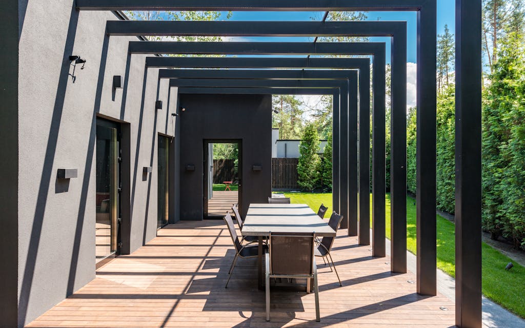 Pergola bioclimatique moderne en aluminium au-dessus d'une terrasse avec table