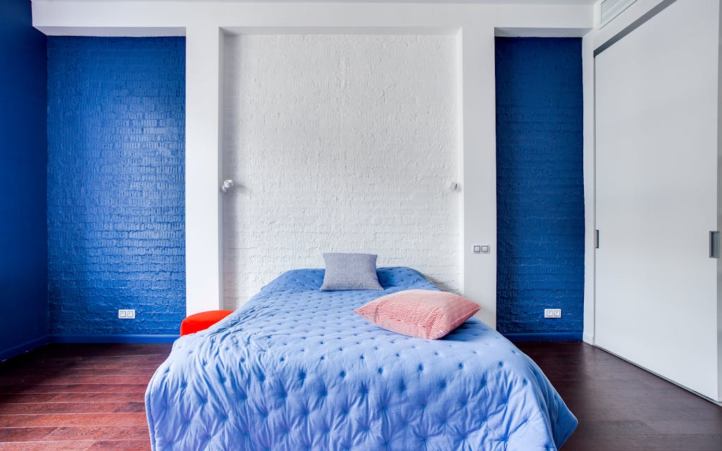 Chambre avec un mur d'accent peint derrière la tête de lit