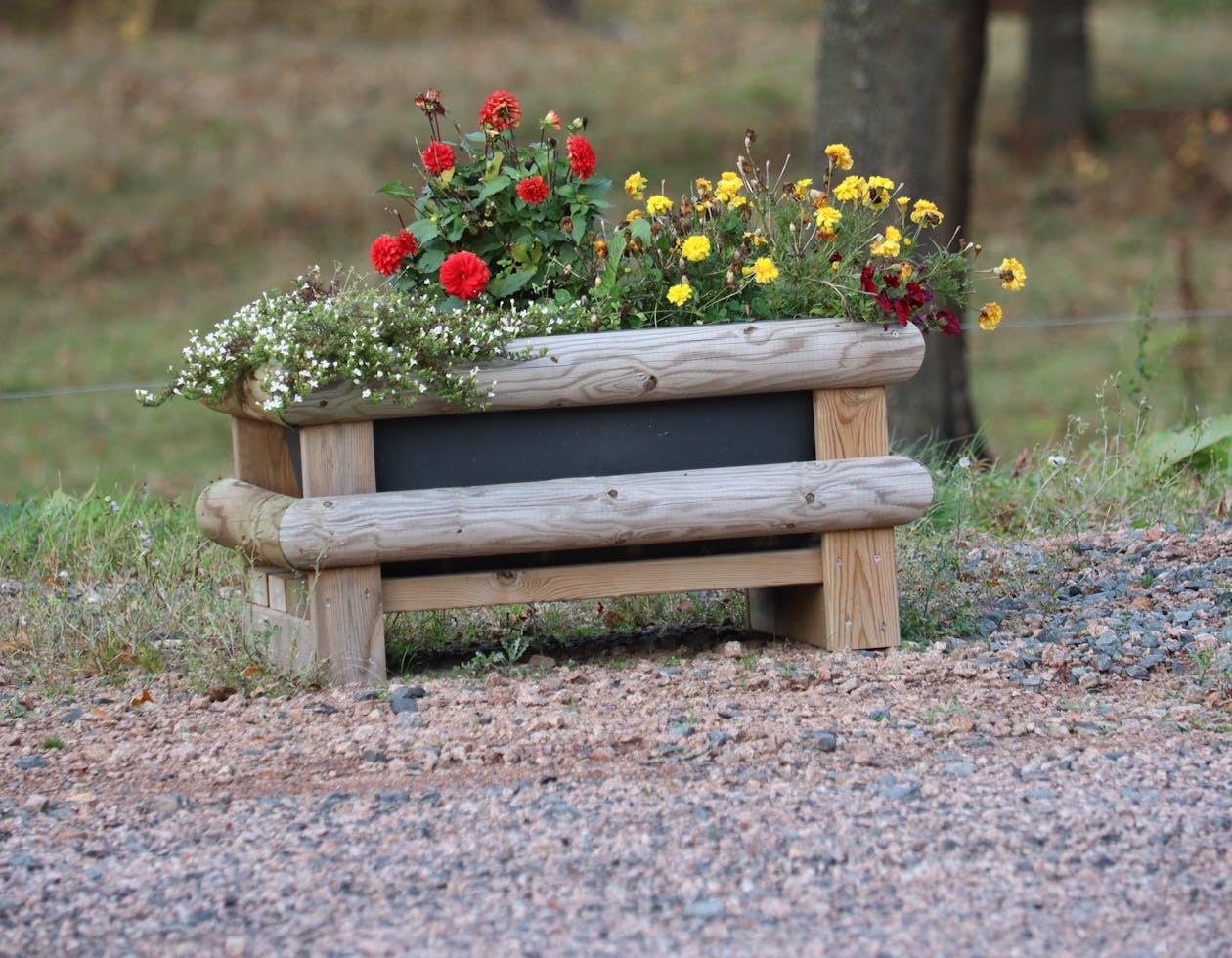 Jardinière en bois naturel avec fleurs colorées sur terrasse