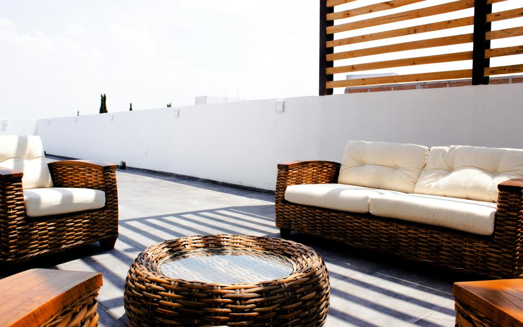 Terrasse extérieure avec salon de jardin et végétation