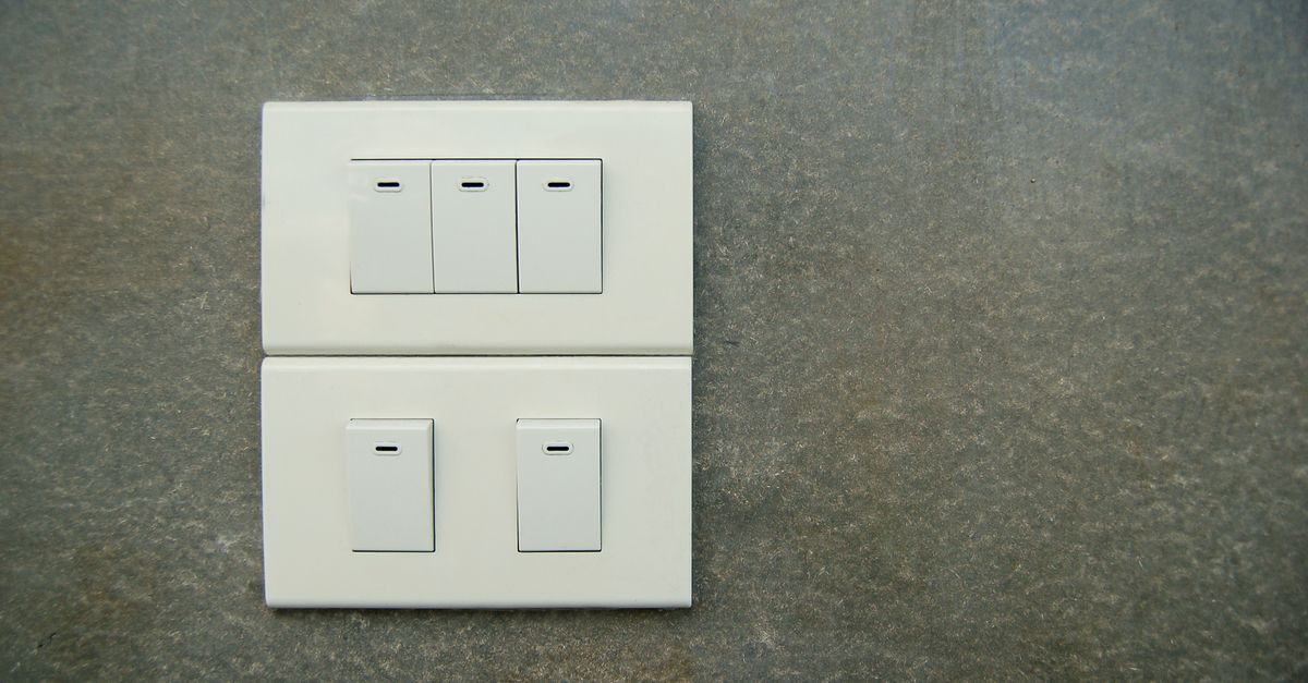 Boîte d'encastrement ouverte avec mécanisme d'interrupteur et fils électriques visibles