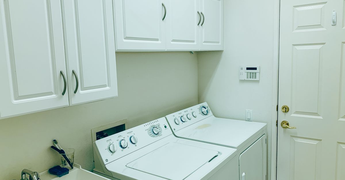 Buanderie compacte avec colonne lave-linge et rangements muraux