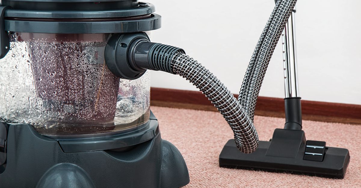 Aspirateur balai sans fil utilisé sur un parquet de salon