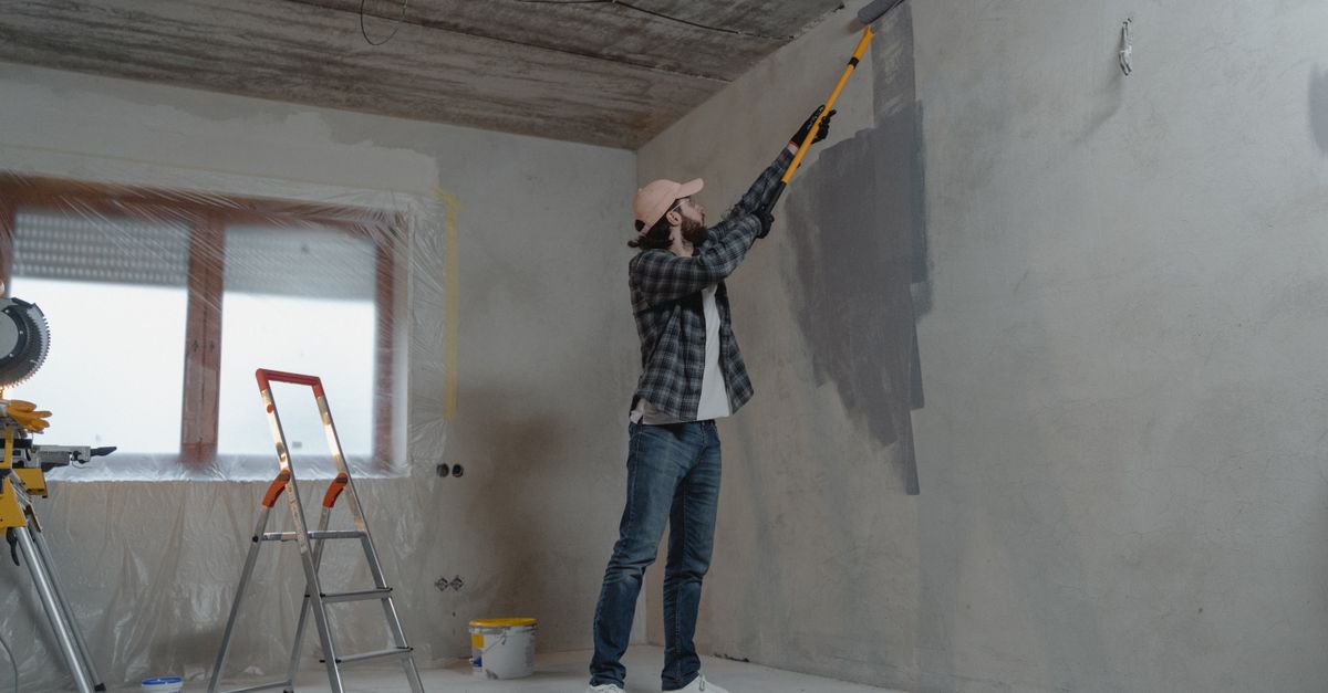 Personne peignant un plafond en blanc