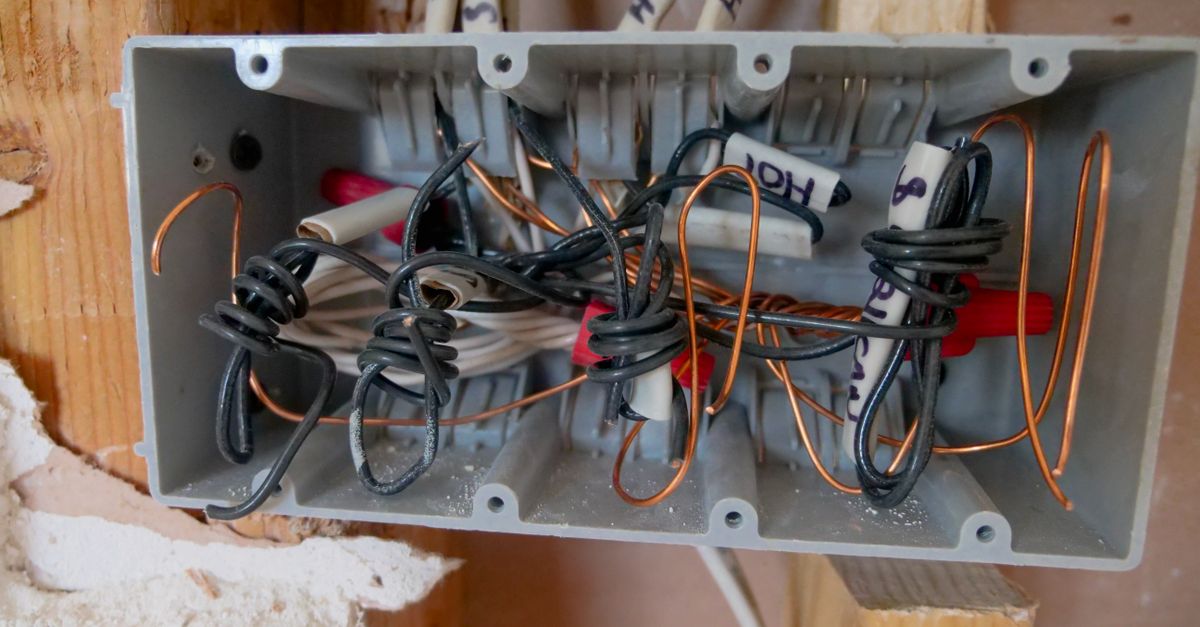 Électricien câblant une boîte de dérivation