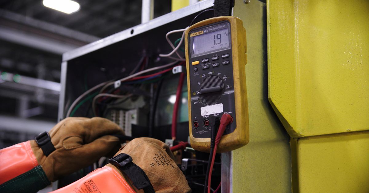 Multimètre testant la continuité de terre sur une prise électrique démontée